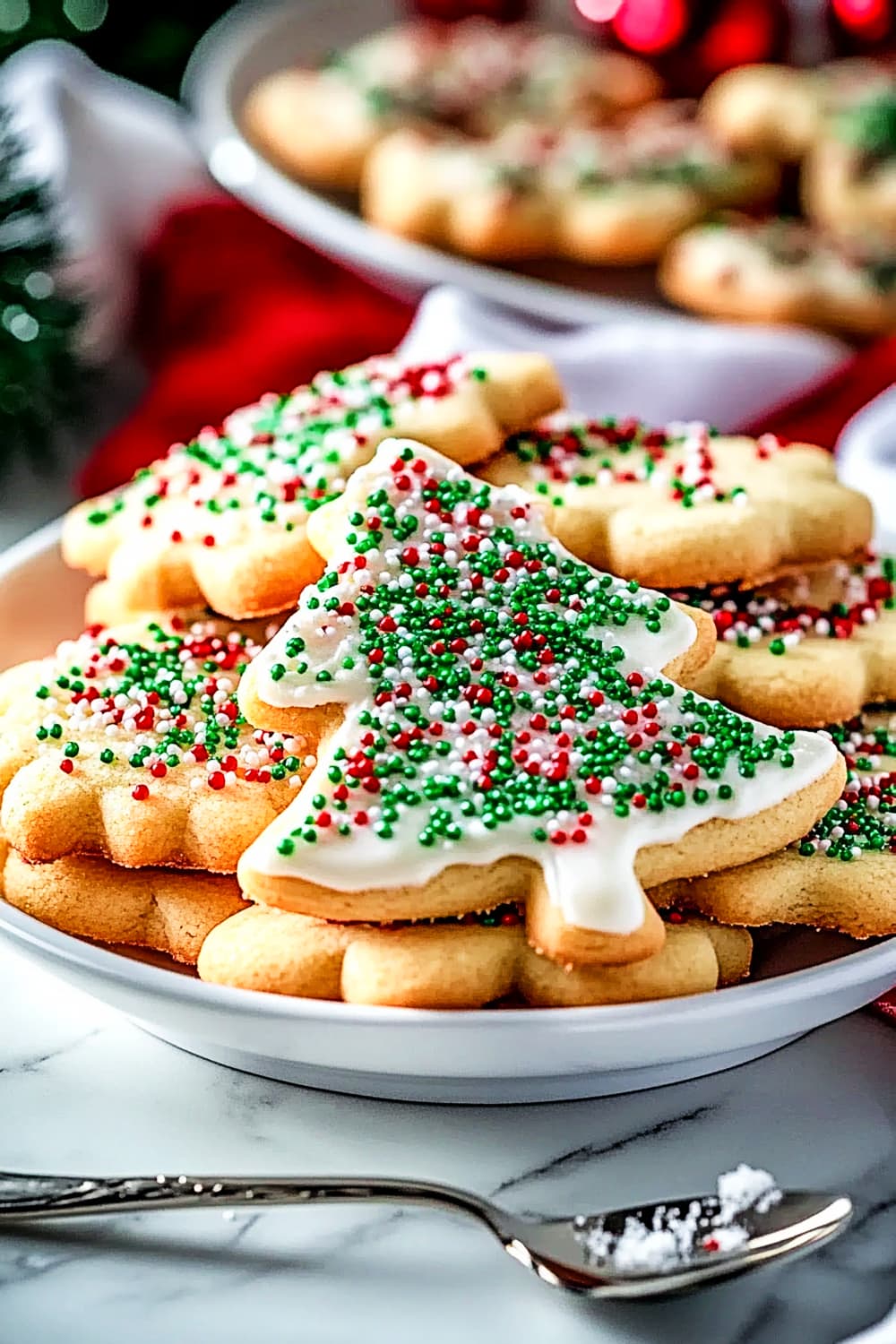 Fluffy sugar cookies in christmas tree shape with sprinkles and cream cheese frosting