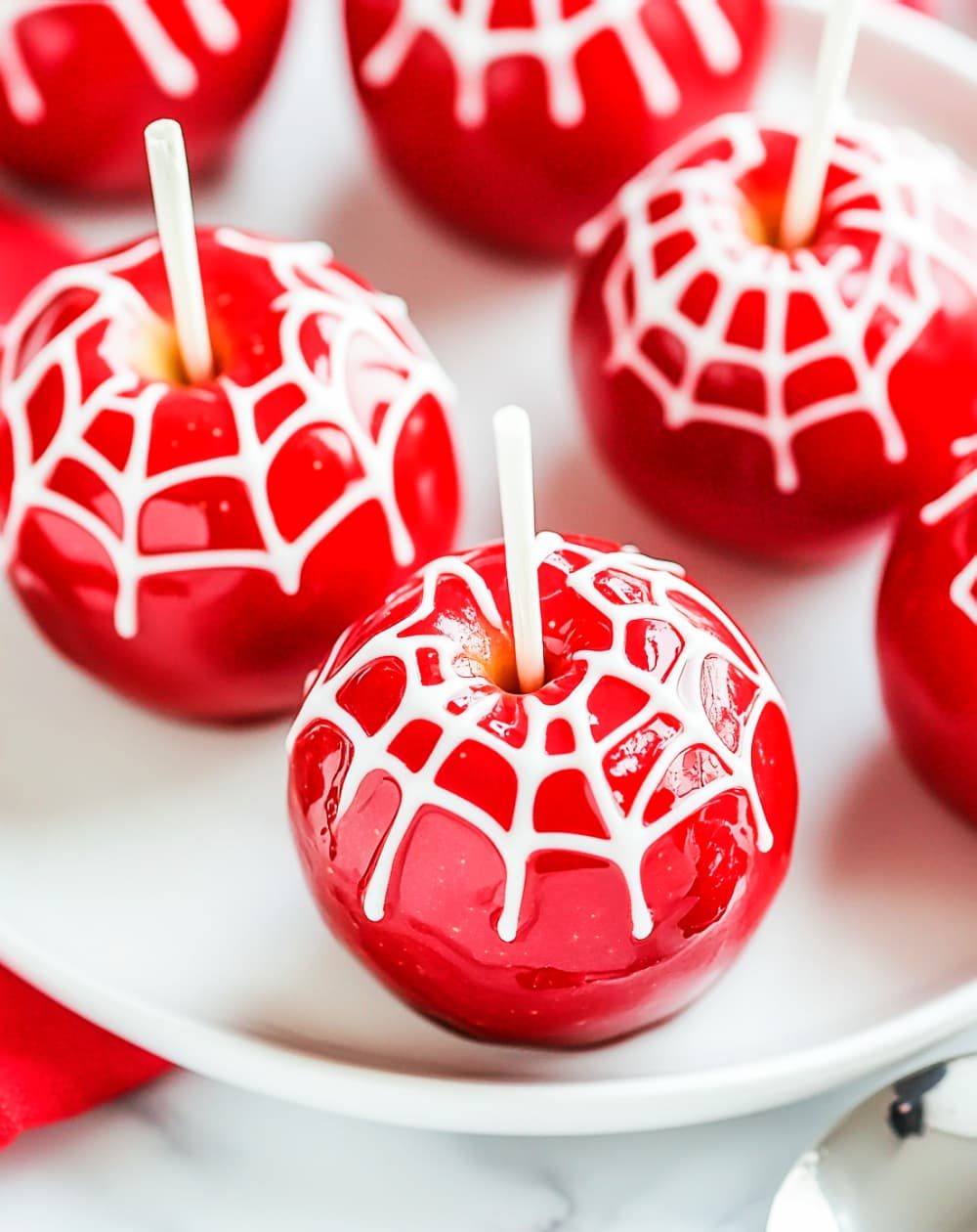 red candy apple with white chocolate webs