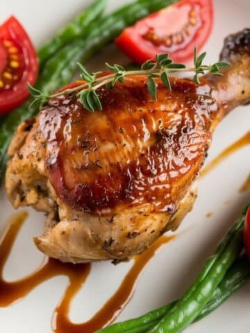Glazed Roasted Chicken Quarters Recipe – Juicy, oven-baked chicken quarters with a flavorful herb marinade, served with fresh green beans and cherry tomatoes, drizzled with a savory sauce. Perfect for a hearty and delicious meal.