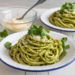 Delicious Green Spaghetti Recipe served on a white plate, topped with creamy poblano sauce, fresh cilantro, and grated cheese. A flavorful and easy-to-make pasta dish perfect for dinner.