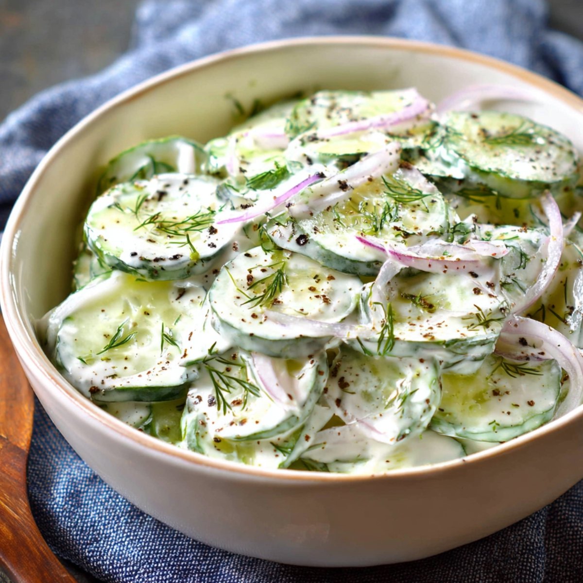 Creamy cucumber salad with red onion, fresh dill, and black pepper.