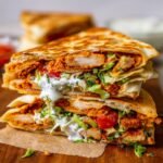 Healthy Chicken Crunch Wrap with golden tortilla, crispy chicken, lettuce, tomato, onion, cheese, and sauce