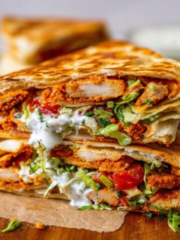 Healthy Chicken Crunch Wrap with golden tortilla, crispy chicken, lettuce, tomato, onion, cheese, and sauce