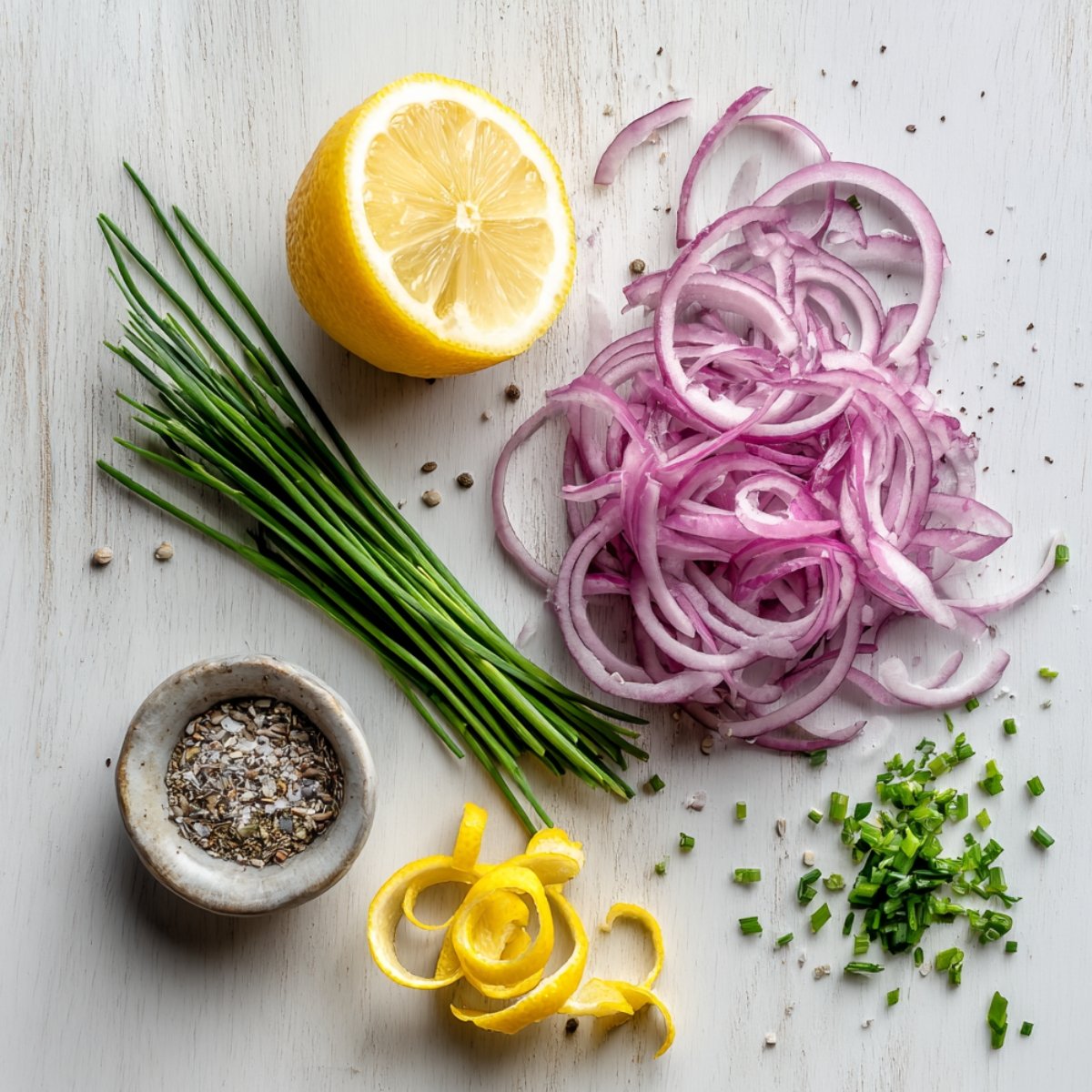 Fresh red onion, chives, lemon, and celery seed for cucumber salad.