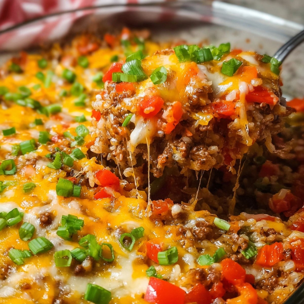 Cheesy homemade stuffed pepper casserole with beef, rice, peppers, and fresh herbs in a baking dish.
