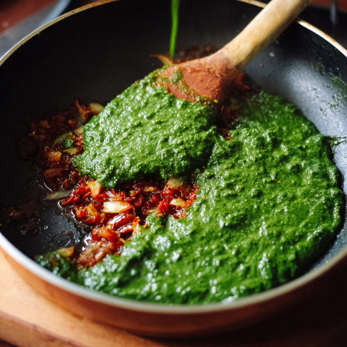 Pour the spinach puree into the pan and mix it well with the onion-tomato base.