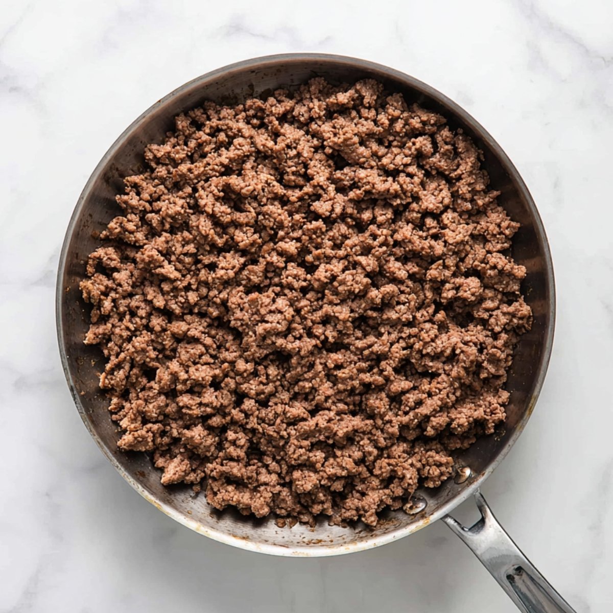 Brown your ground beef in a skillet over medium heat. Break it up as it cooks, and once it's no longer pink, drain off any extra grease. Set it aside.