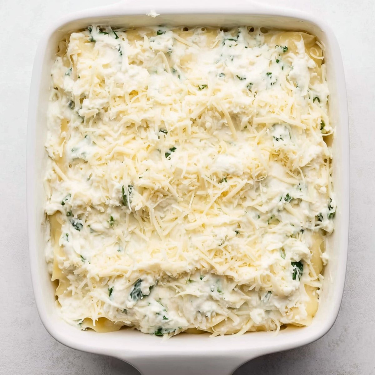 Repeat this layering two more times. You'll end up with three beautiful layers. Finish with a final layer of sauce and sprinkle extra mozzarella on top. Cover the whole thing with aluminum foil.