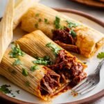 Finished Tamales Recipe served with a delicious filling and a sprinkle of cilantro.