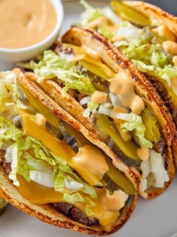 Big Mac Smash burger Tacos with pickles, lettuce, and melted cheese inside soft taco shells with drizzle of special sauce.