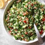 The final mixed Cauliflower Tabbouleh, with a blend of cauliflower rice, tomatoes, cucumbers, green onions, and parsley, ready to be served.