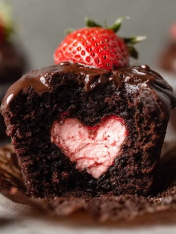 Chocolate Covered Strawberry Cupcakes with a heart-shaped strawberry filling, topped with ganache and a strawberry.