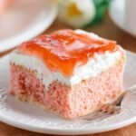 Slice of Hawaiian Guava Cake with cream and jelly topping.